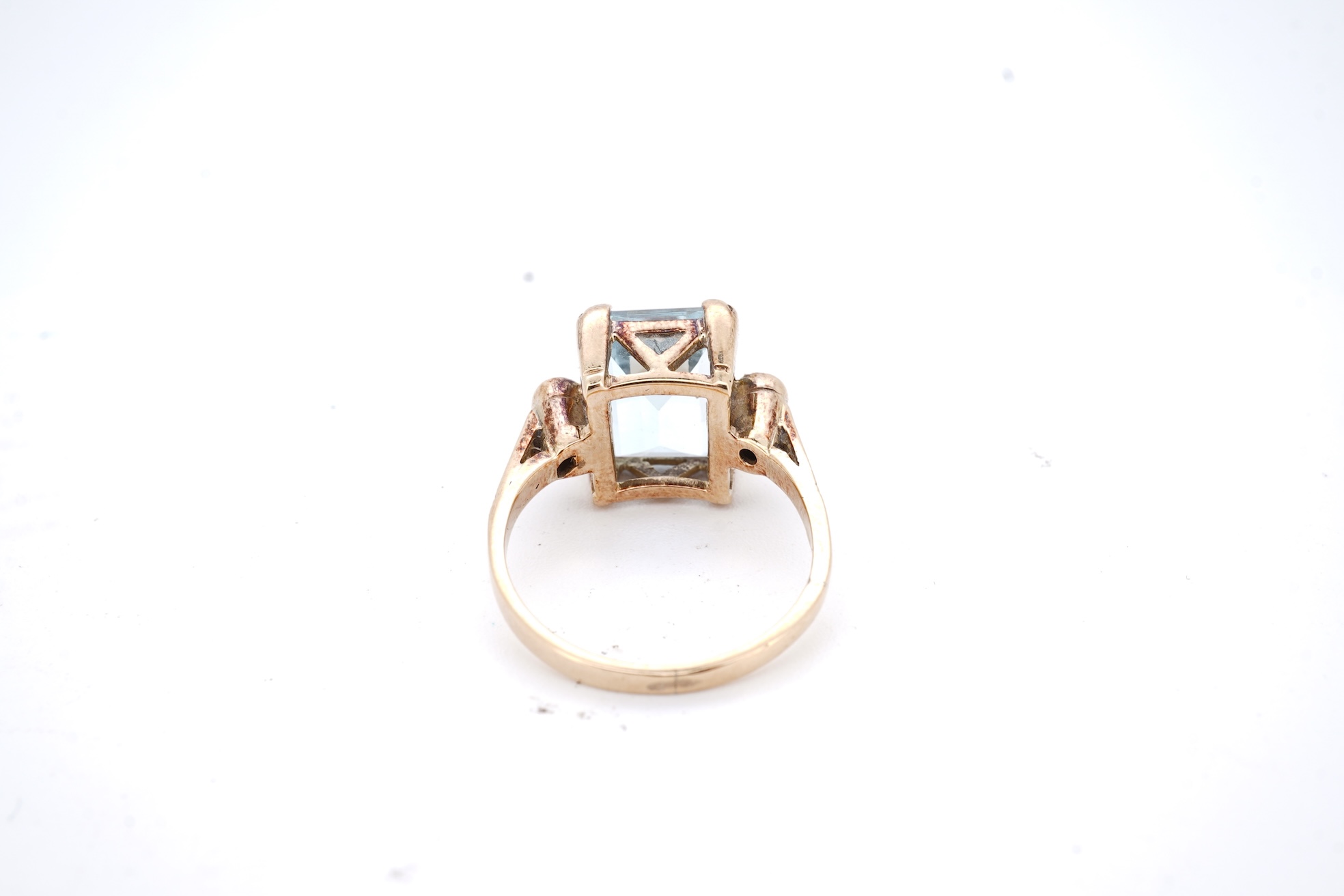 A yellow metal and single stone emerald cut aquamarine set ring, with two stone diamond set shoulders, size M, gross weight 4.2 grams.